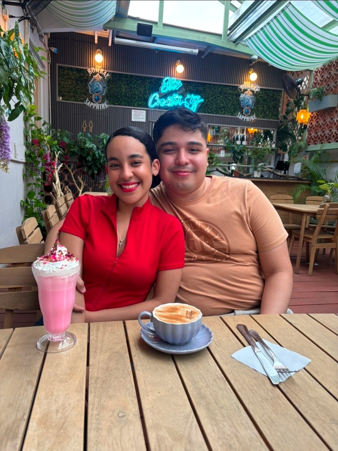 Yinelis y su pareja sonriendo juntos en una cafetería