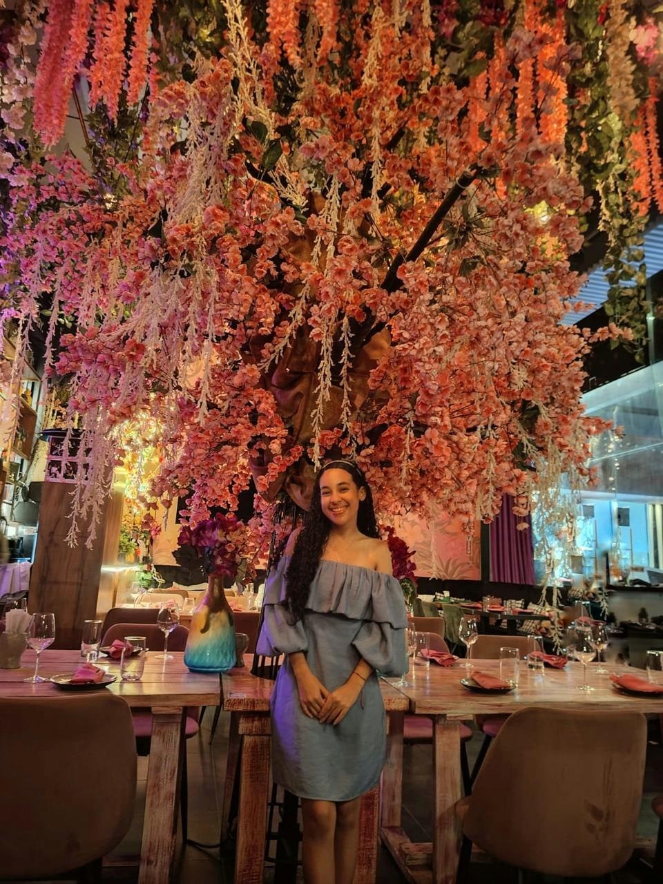Yinelis bajo un árbol de flores rosadas