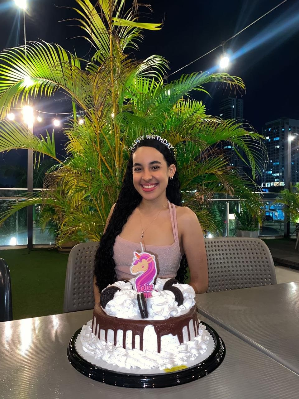 Yinelis sonriendo frente a su pastel de cumpleaños
